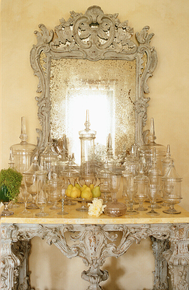 Antique mirror above console with baroque-style glass jars