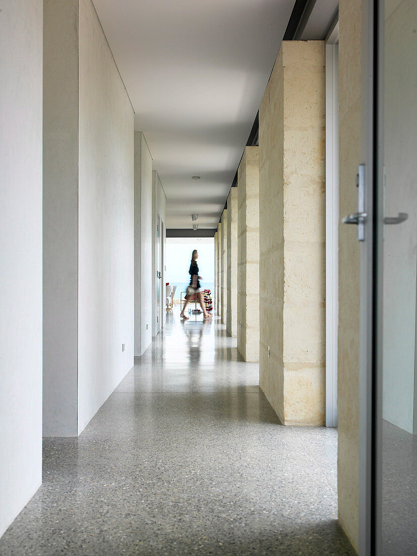 Bright hallway between doors and windows with natural stone walls