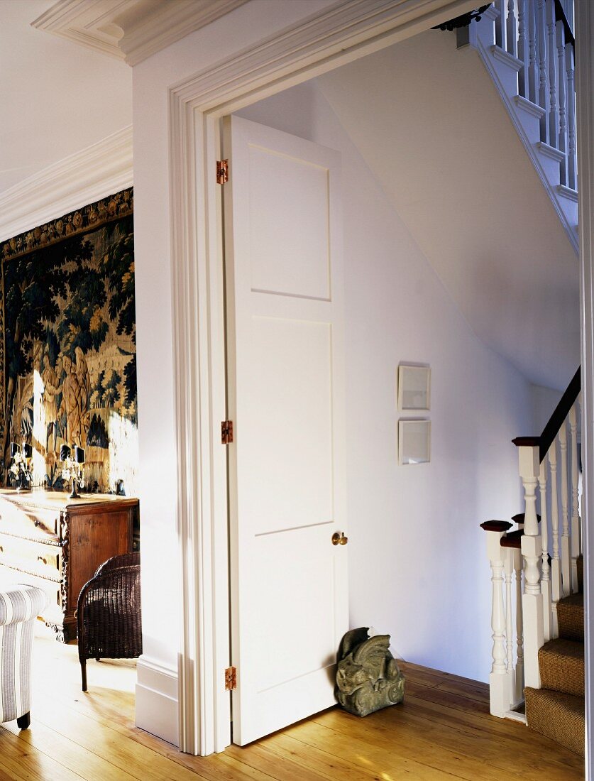 View of traditional stairwell through white-painted, open double doors