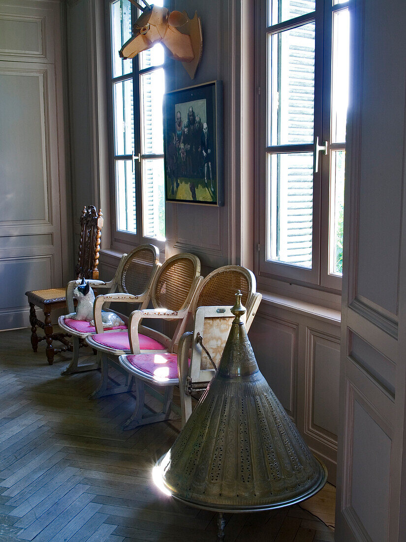 Room with vintage furniture, parquet flooring and windows with shutters