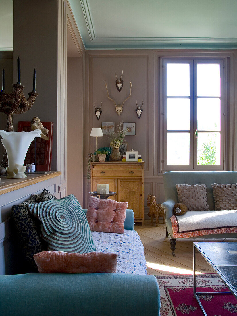 Living room with classic furniture, antler decorations and oriental carpet