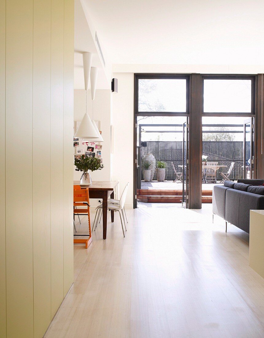 Open-plan living and dining room with floor-to-ceiling terrace windows