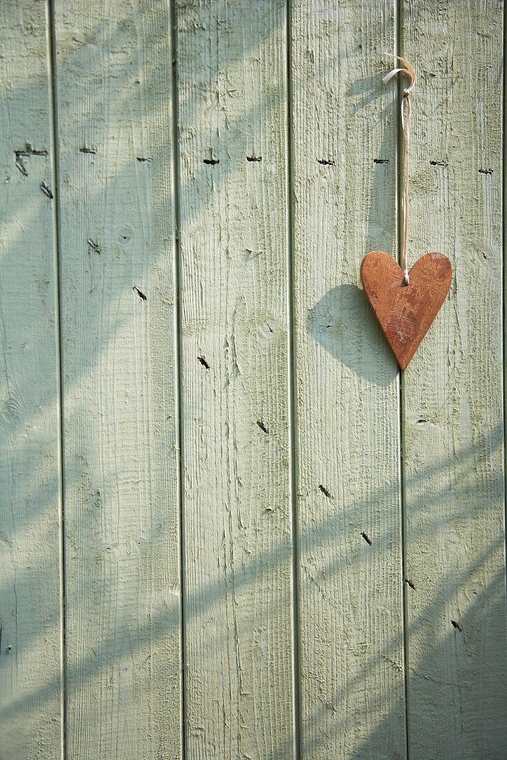 Ein Herz hängt an einer Holztür