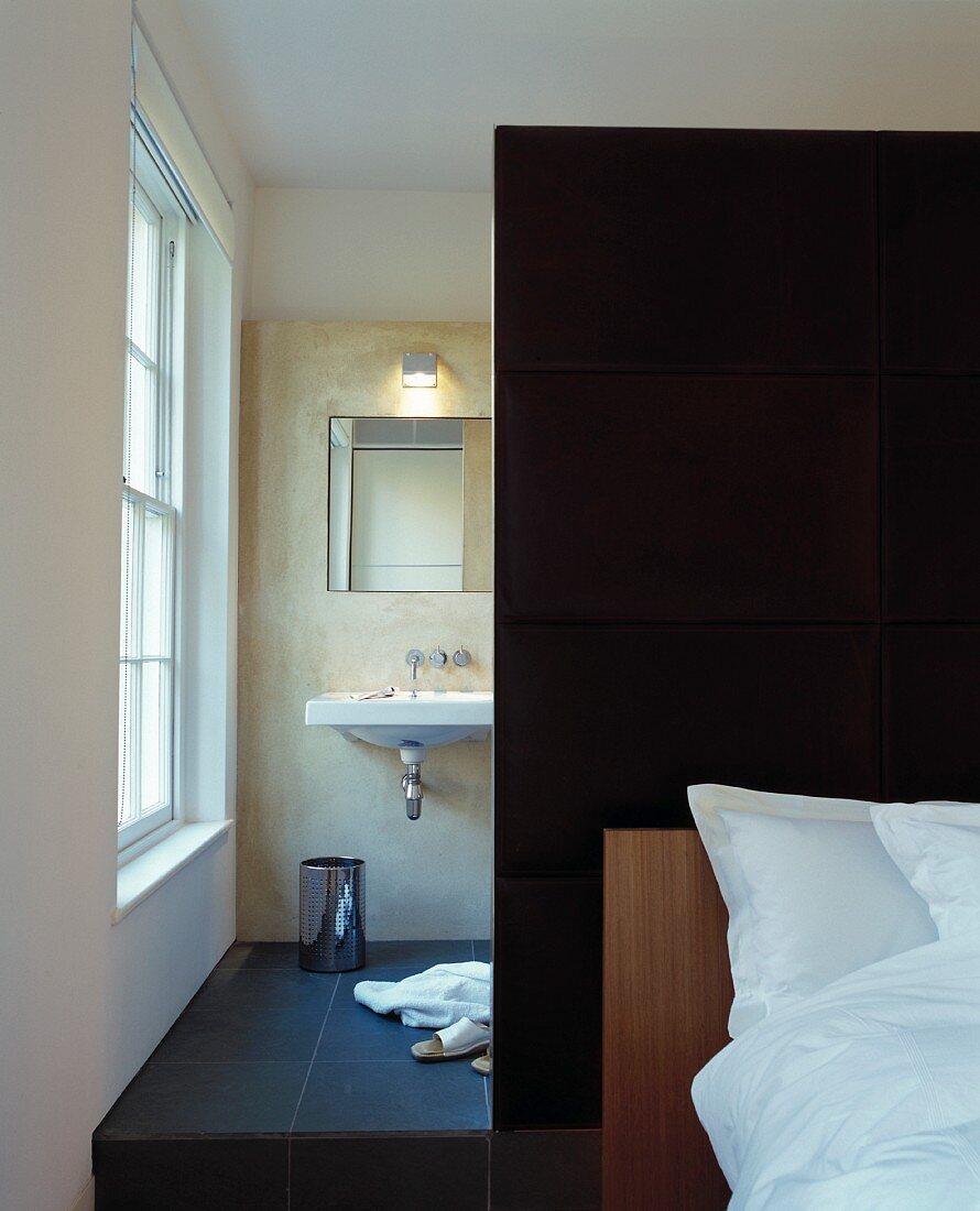 Modern bedroom with partition in front of ensuite bathroom