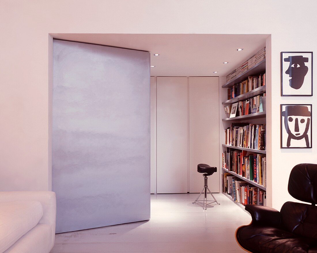 Living space with angled partition and view of bookcase