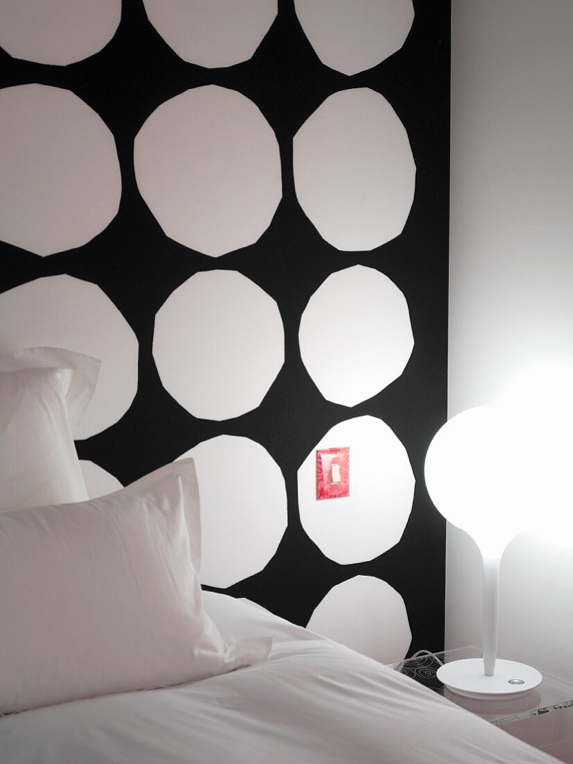 Expressive Wandgestaltung in Hotelzimmer mit weissen unrunden Kreisen auf schwarzem Grund