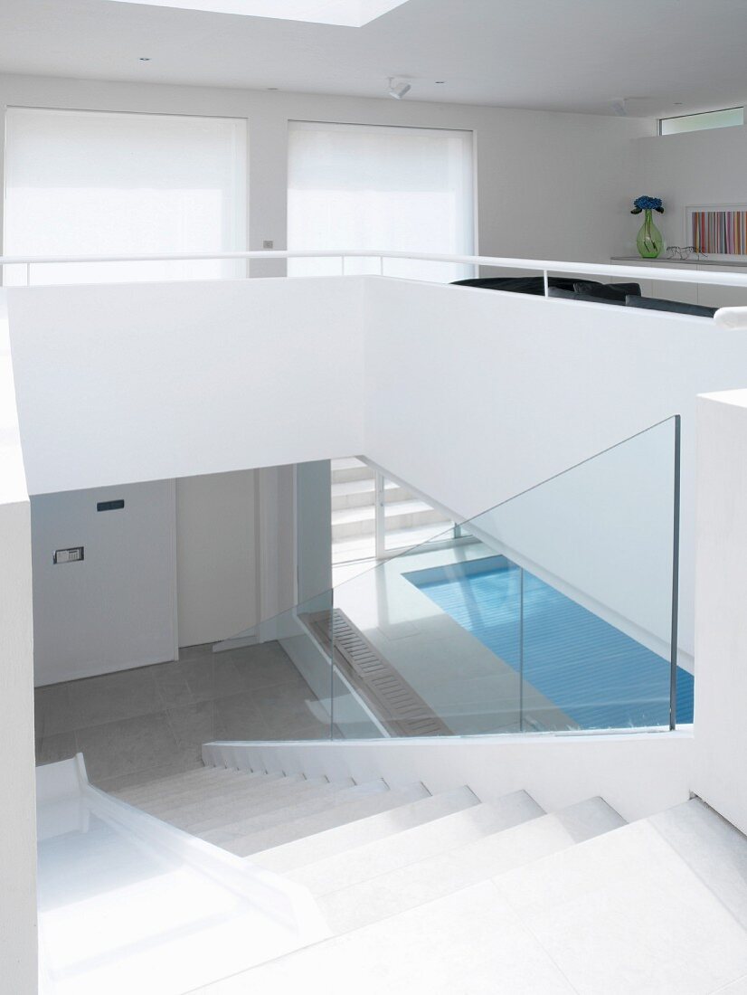 Treppenabgang vom offenen Wohnzimmer mit Blick auf besonnten Haus-Pool