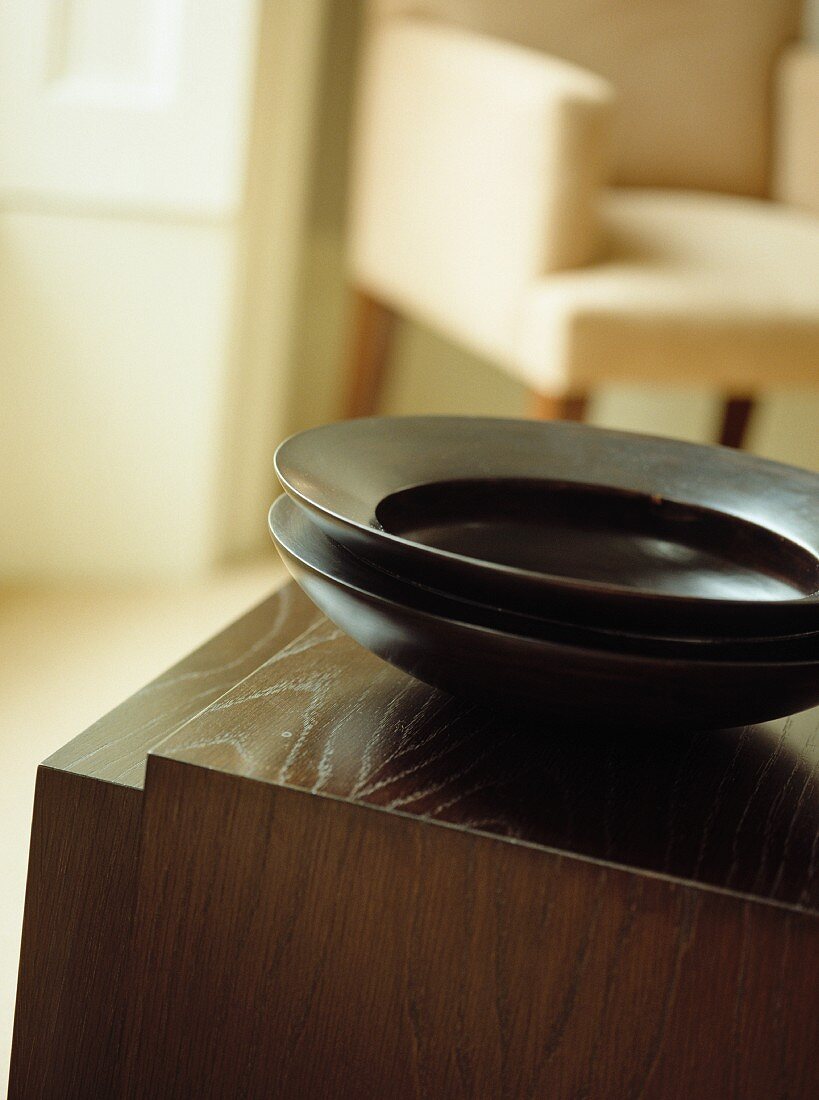 Dark, exotic bowls on traditional wooden cabinet
