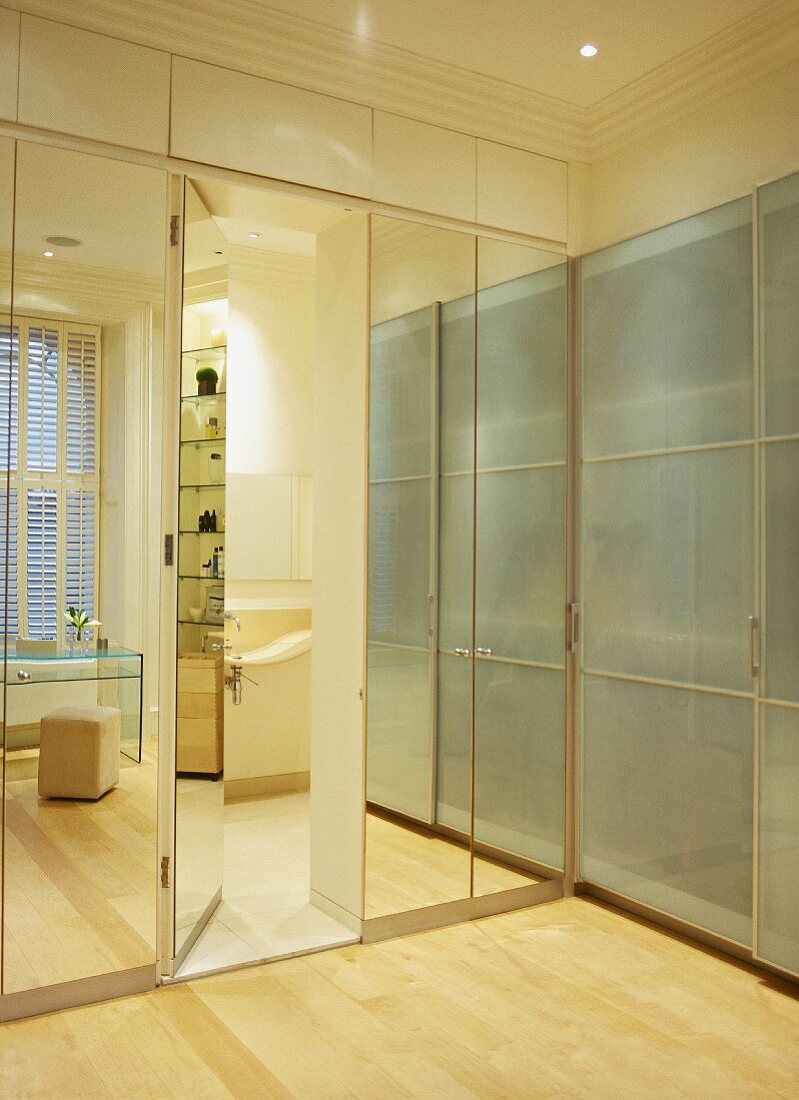 Glas- und Spiegelfronten an zeitgenössischen Schrankeinbauten mit integrierter Tür zum Bad ensuite
