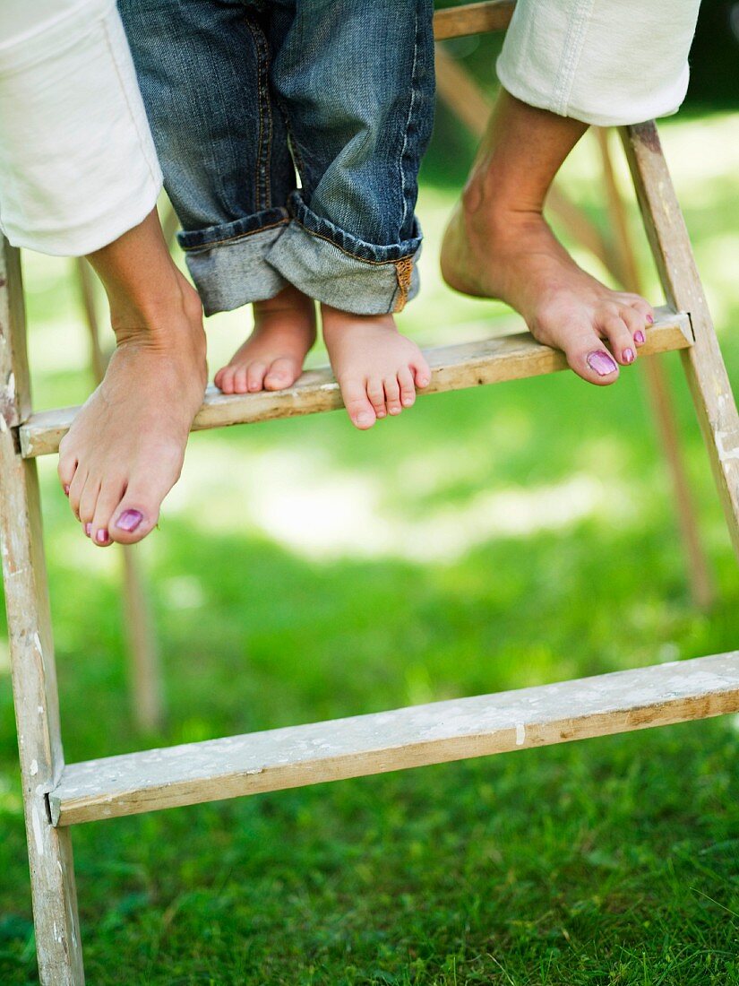 Woman's and child's feet on ladder