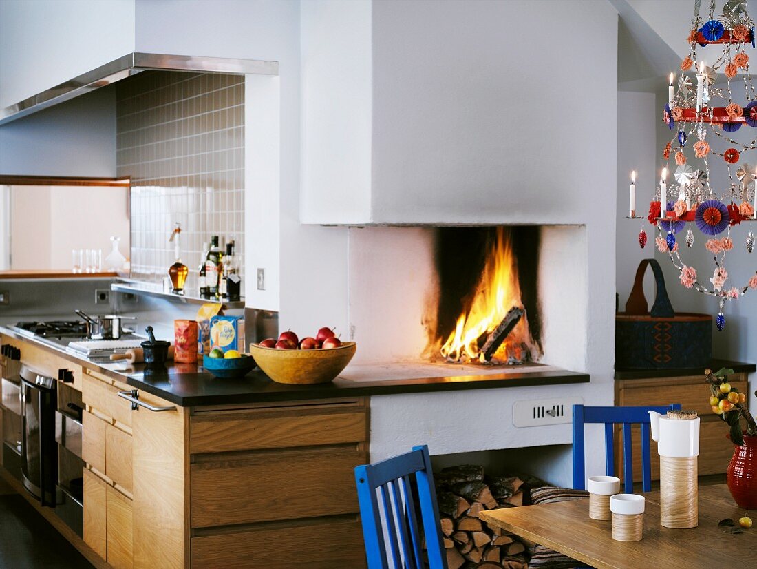 Offener Kaminofen mit Feuer in moderner Küche
