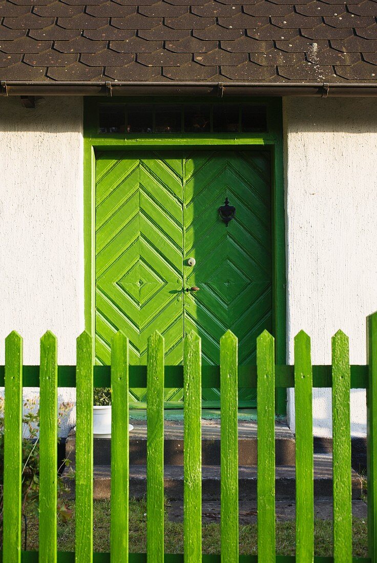 Country home with a green door and fence