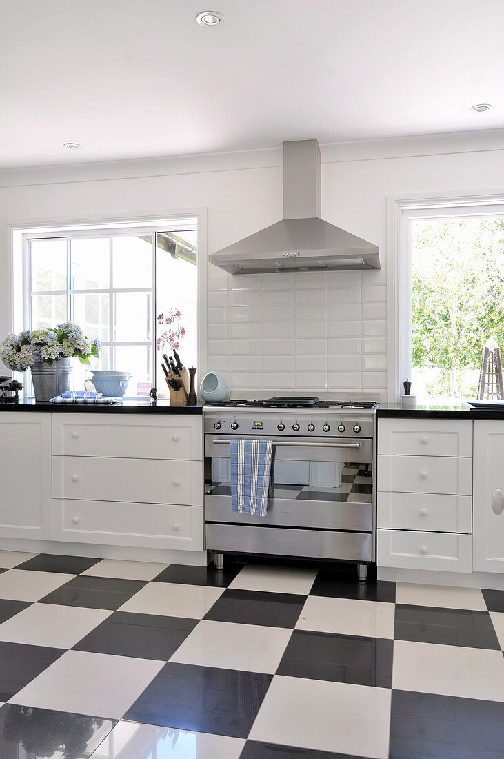 Vintage kitchen with stainless steel cooker and black and white chequered floor