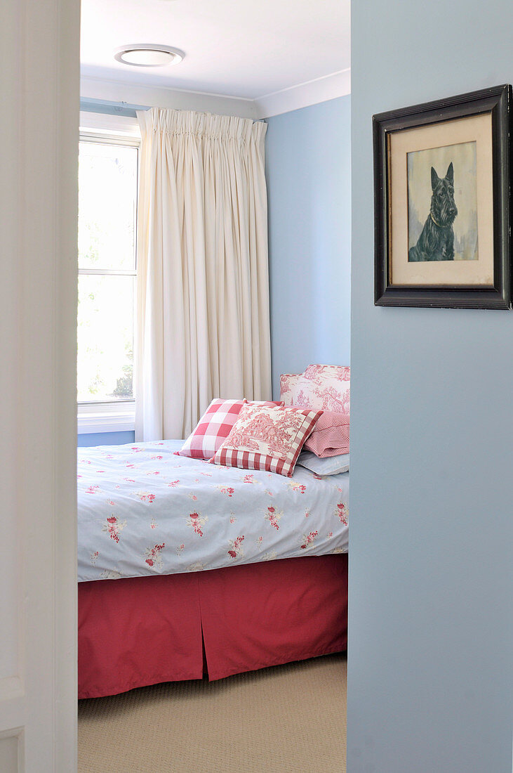 Blick durch offene Tür auf Bett in hellblau getöntem Schlafraum