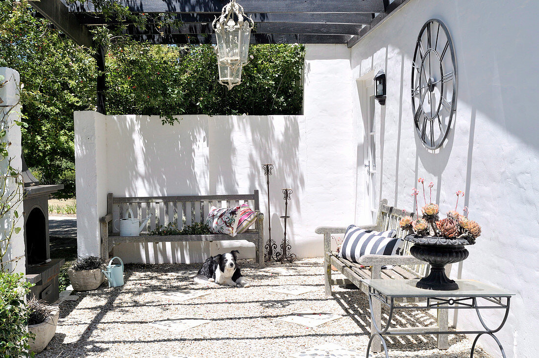 Sunny terrace with plain wooden benches against whitewashed walls