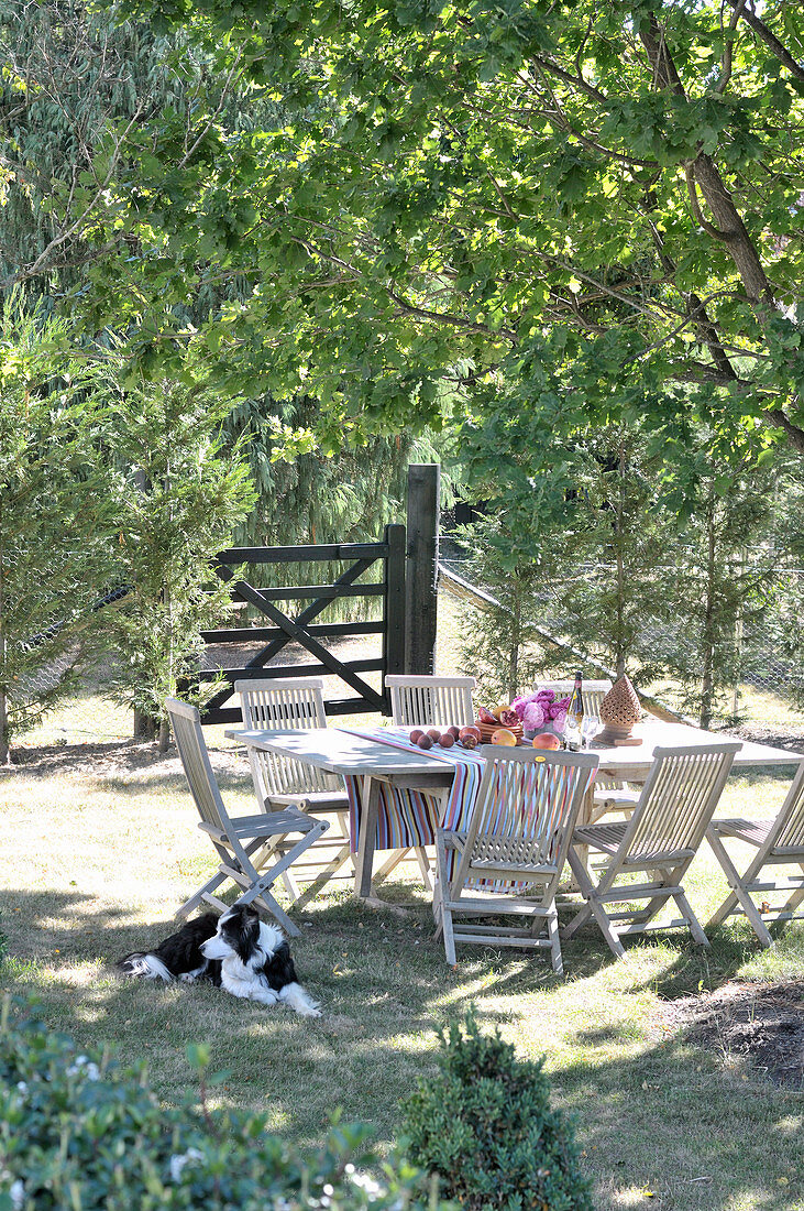 Sonniges Gartenplätzchen mit Tisch und Stühlen aus Holz