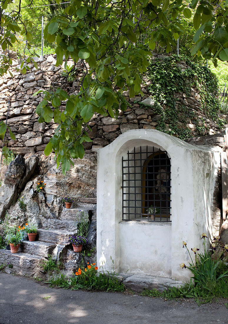 Tiny chapel next to stone steps on mountain road