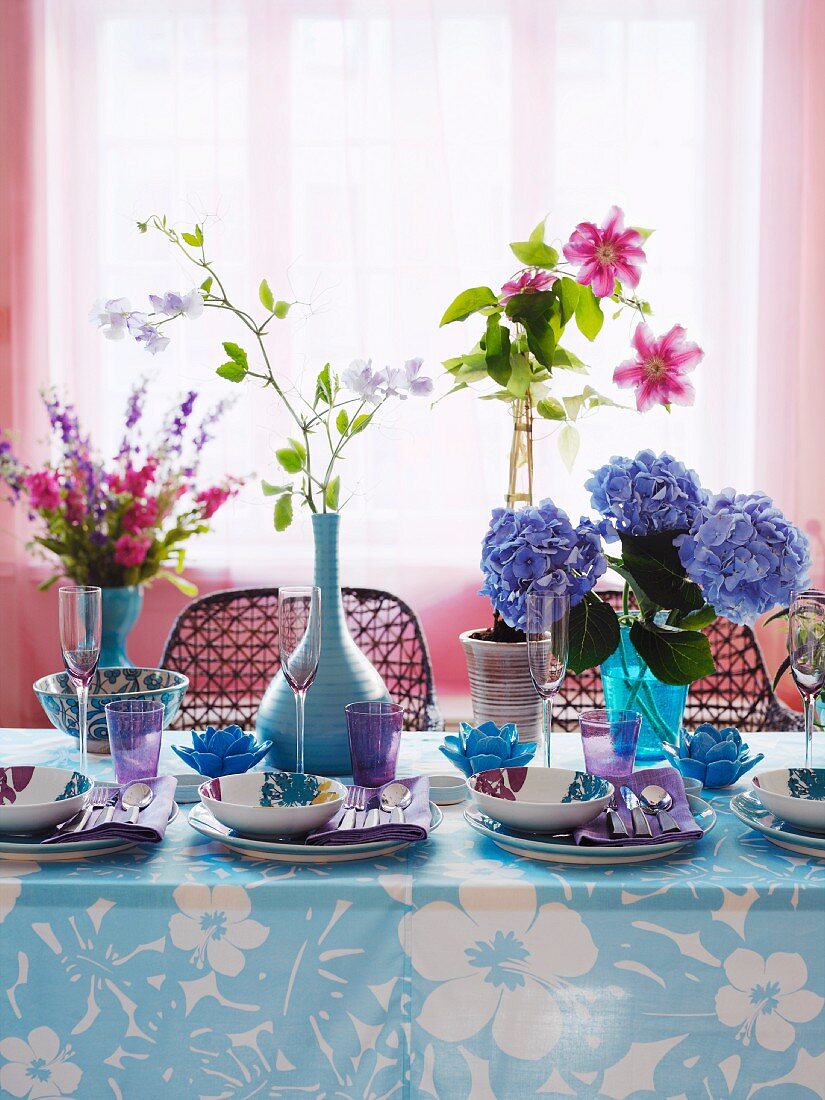 Place settings with patterned bowls and bouquets on a table