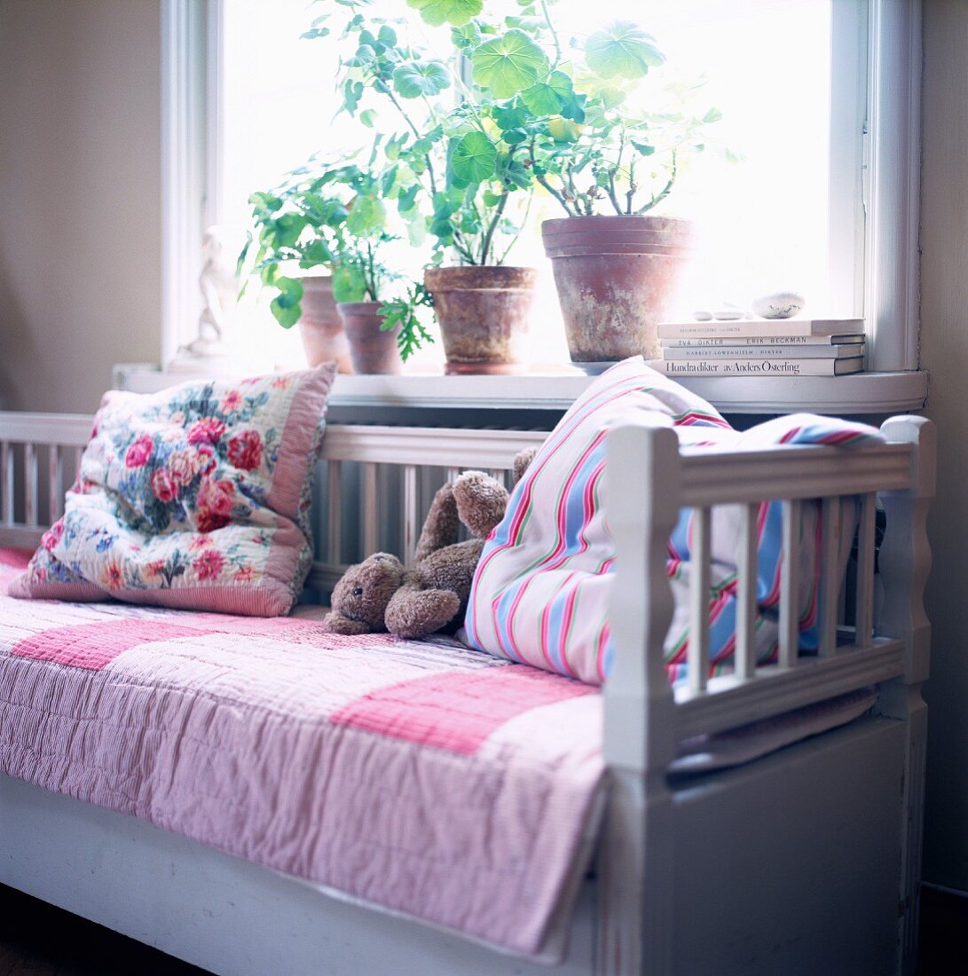 Bench with pillows in front of a window