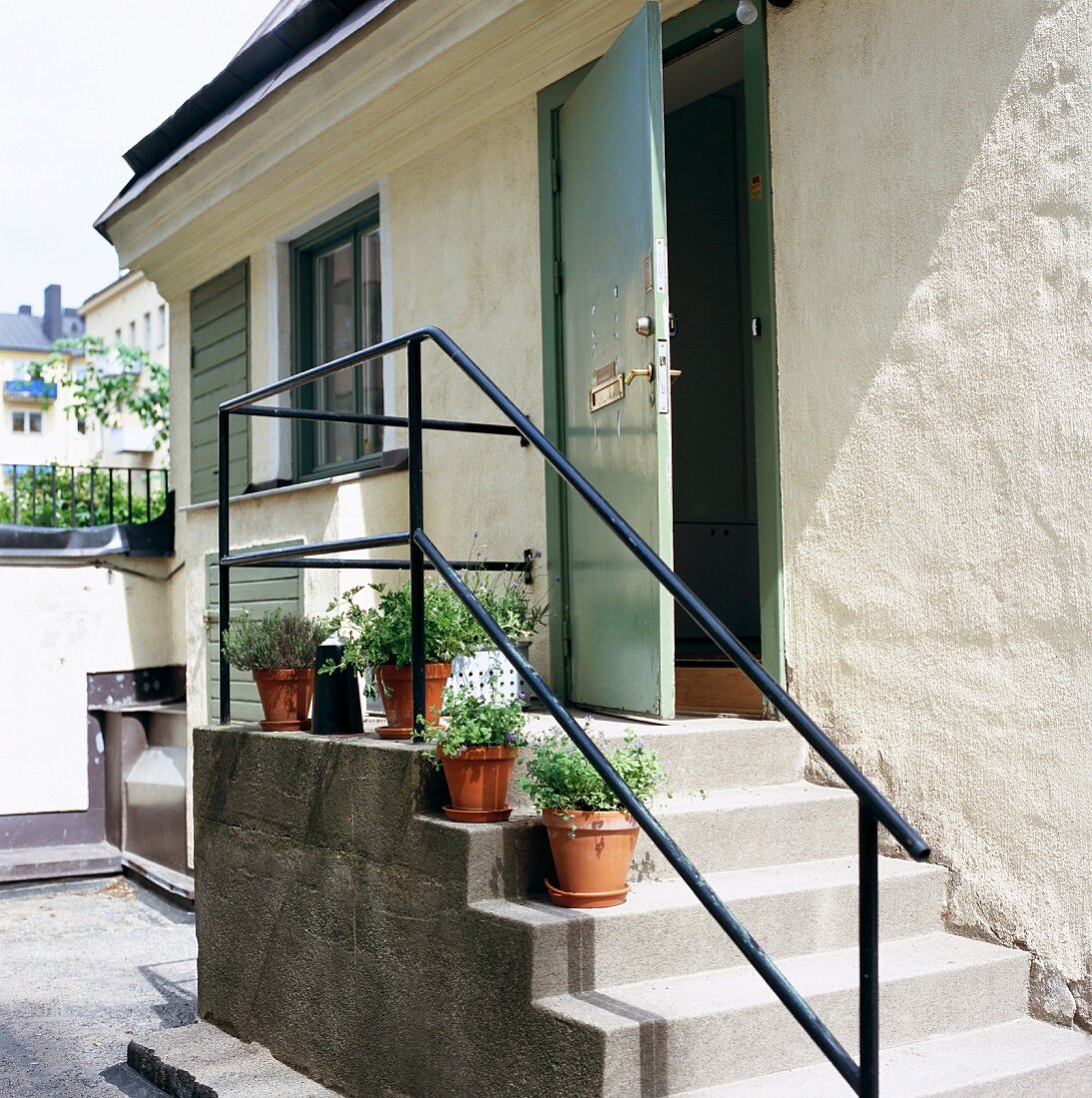 Treppenaufgang vor Wohnhaus mit offenstehender Haustür