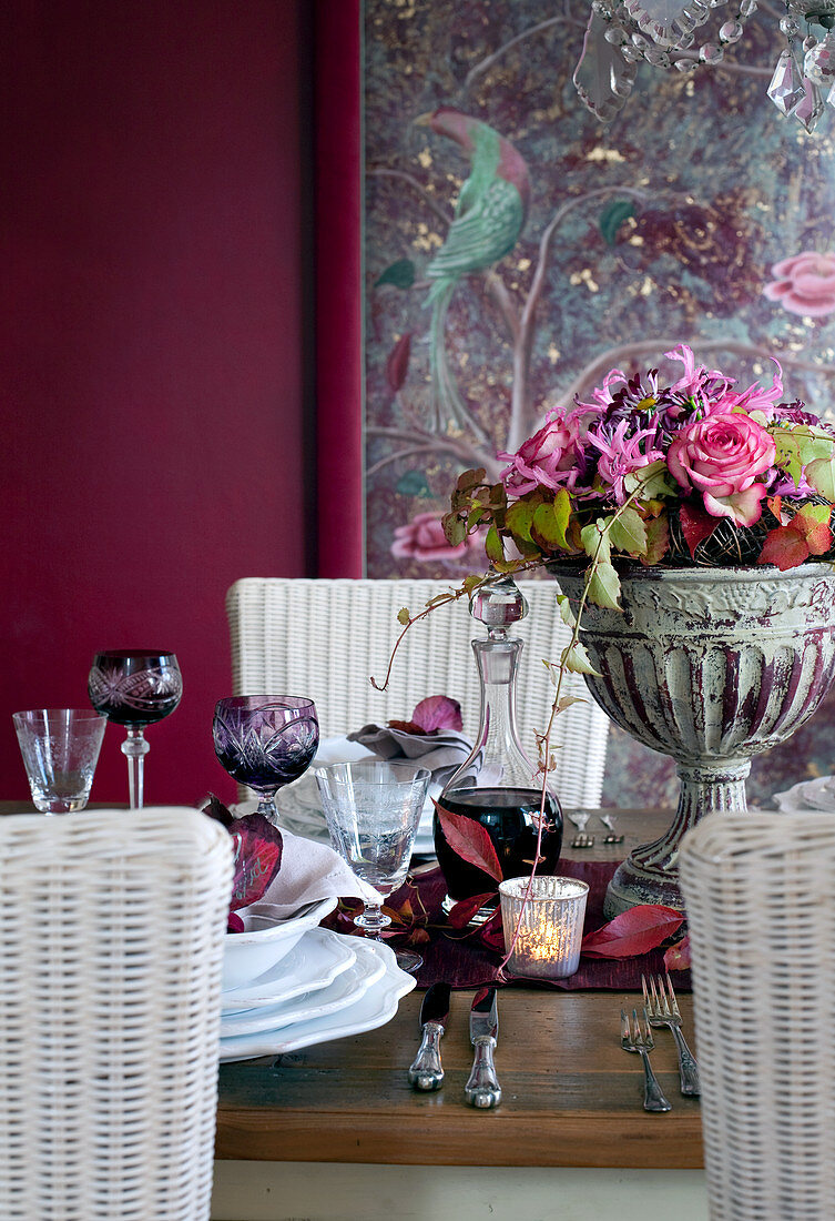 Festlich gedeckter Tisch mit Rotwein und herbstlichem Blumenstrauss