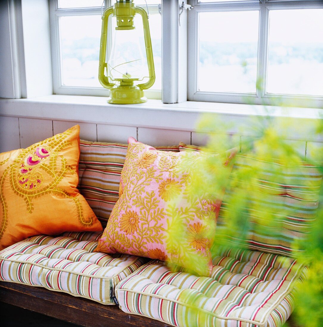 Pillows on an upholstered bench under a window