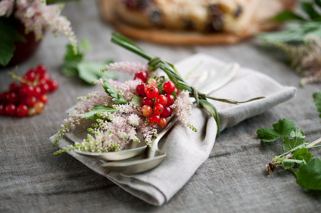 Serviettendeko mit Astilben und roten Johannisbeeren