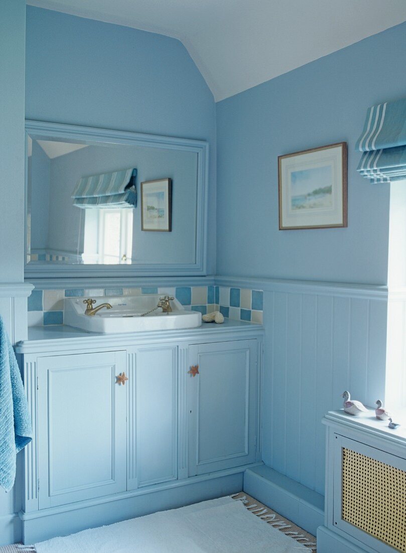 Bathroom painted light blue with fitted washstand in niche