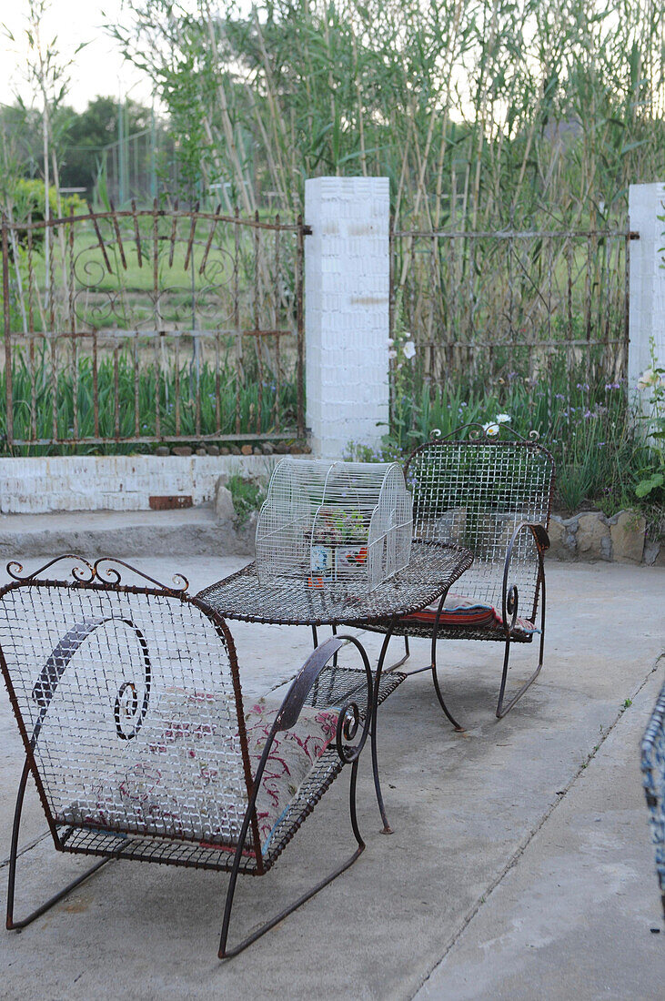 Old wire chairs and table on terrace