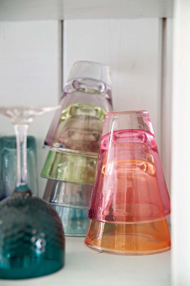 Colourful drinking glasses stacked on shelf