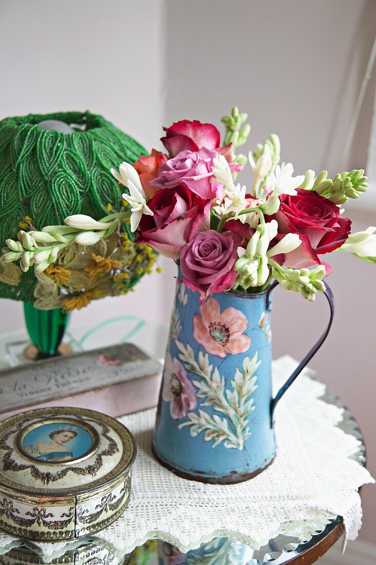 Vintage style, painted metal jug with bouquet of roses