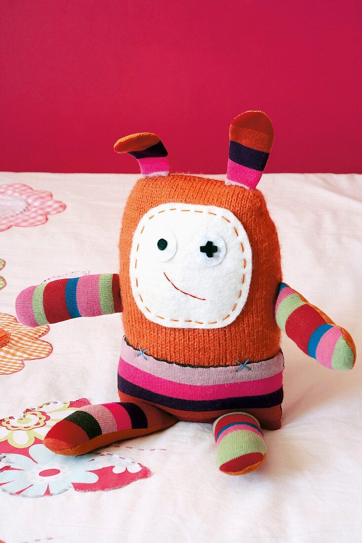 Hand-made rag doll in striped fabric with long ears and embroidered felt face