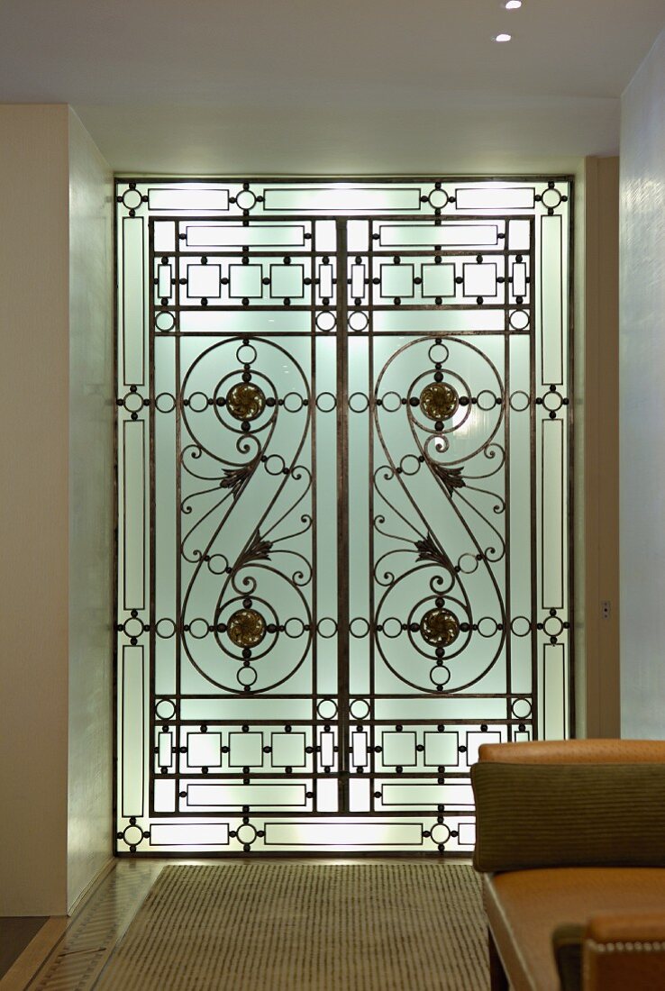 Backlit, floor-to-ceiling glass element with Art Deco geometric pattern