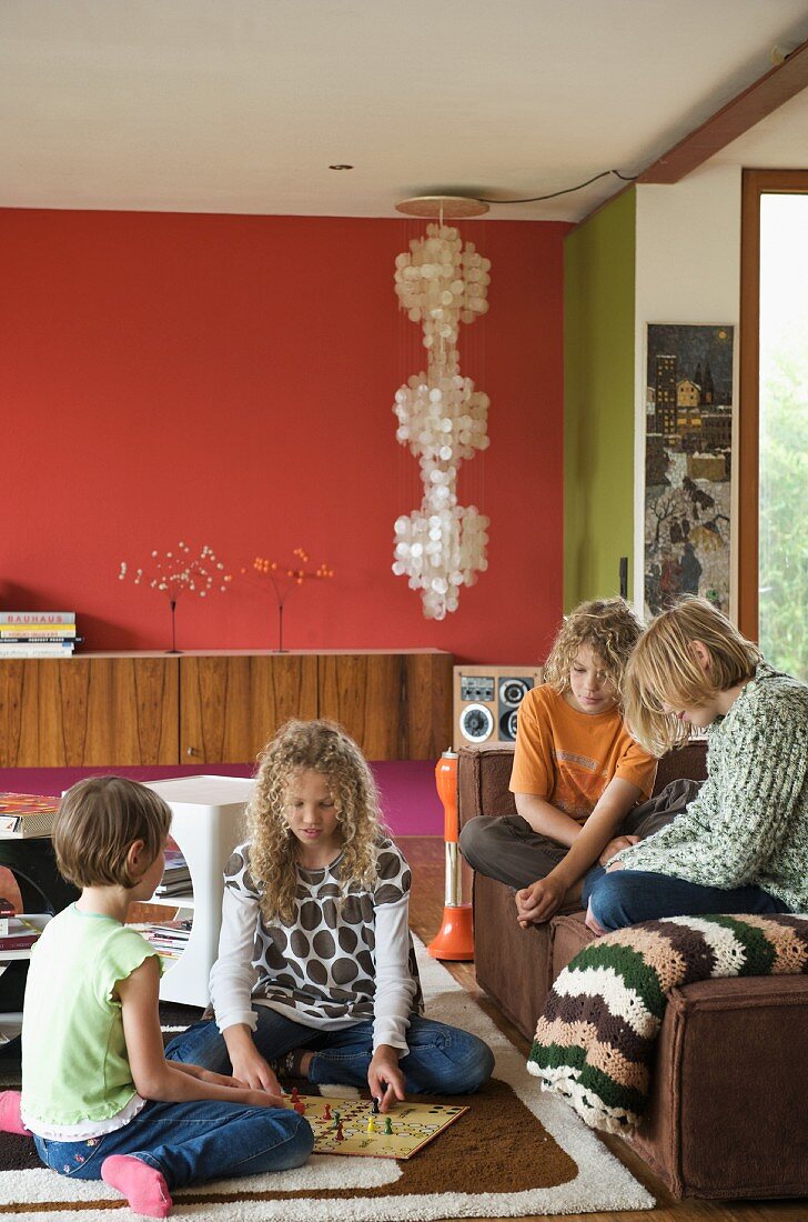 Children playing on rug and sofa in living room