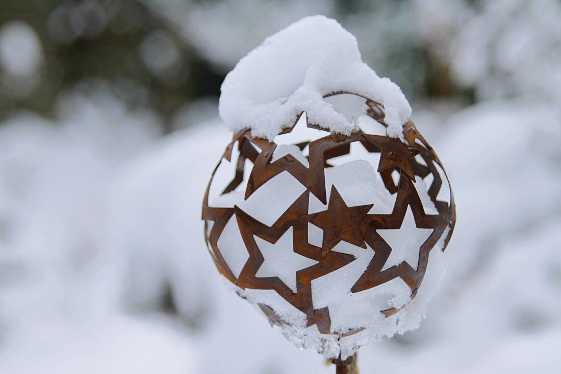 Ball made of rusty metal stars topped and filled with snow