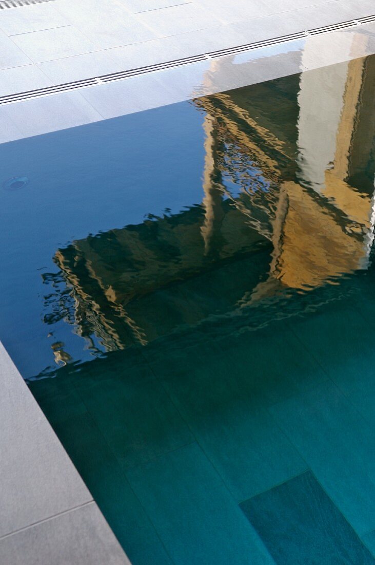 Spiegelnde Wasseroberfläche eines Pools mit Randüberlauf