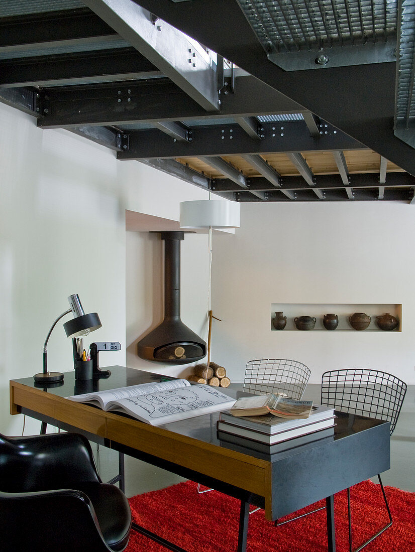 Retro Schreibtisch mit Stühlen aus Drahtgestell in minimalistischem Wohnbereich mit Galerie und sichtbarer Stahlkonstruktion