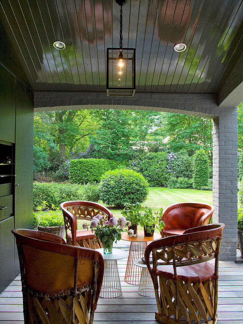 Überdachte Terrasse mit mexikanischen Sitzmöbeln aus Leder und Holz und Designer Beistelltischen