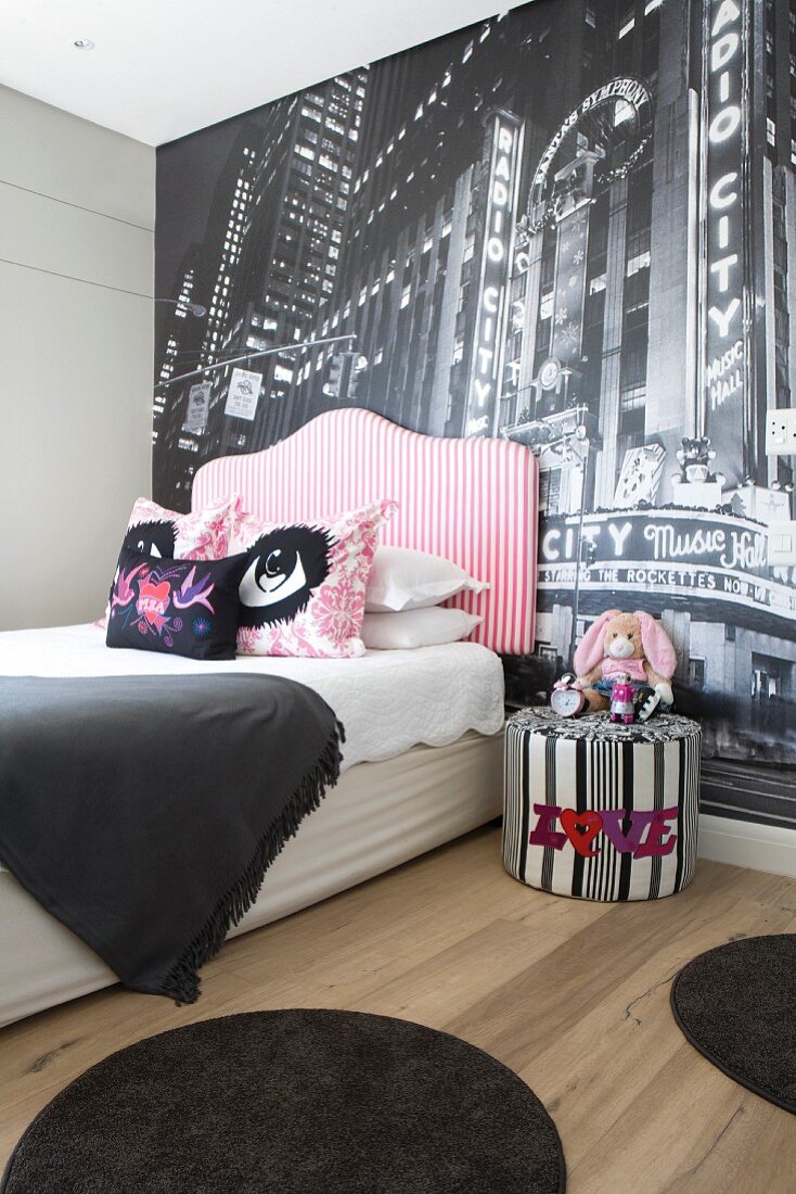 Bett mit gepolstertem Kopfteil vor Fototapete an Wand in modernem Schlafzimmer