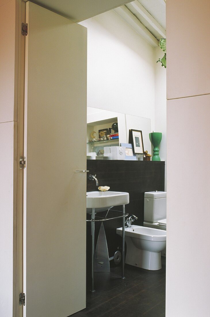 Blick durch offene Tür auf Waschtisch und Sanitärobjekte