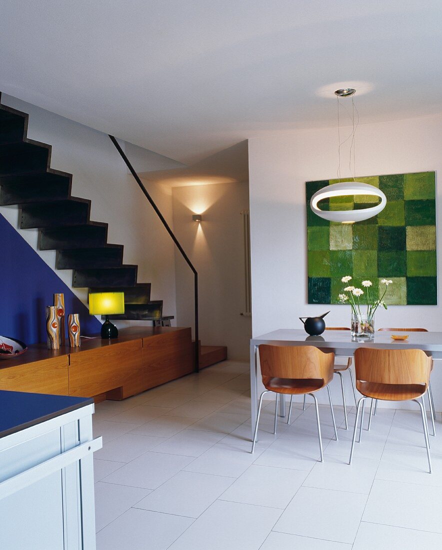 Moderne Holz Schalenstühle mit Retroflair am Esstisch in offenem Wohnraum mit Treppenaufgang