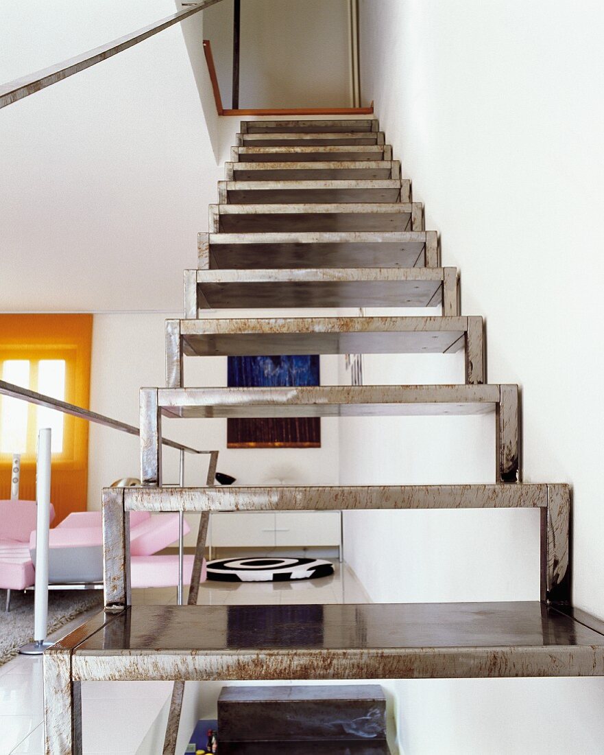 Moderne Stahltreppe an Wand in offenem Wohnzimmer