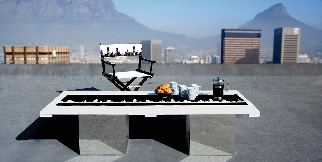 Mit New York Skyline selbst bedruckter Frühstückstisch und Regiestuhl auf Dachterrasse mit grandiosem Fernblick auf den Tafelberg