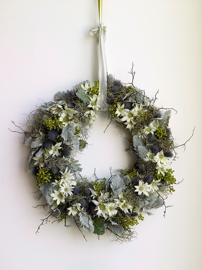 Christmas wreath with white flowers hanging on wall