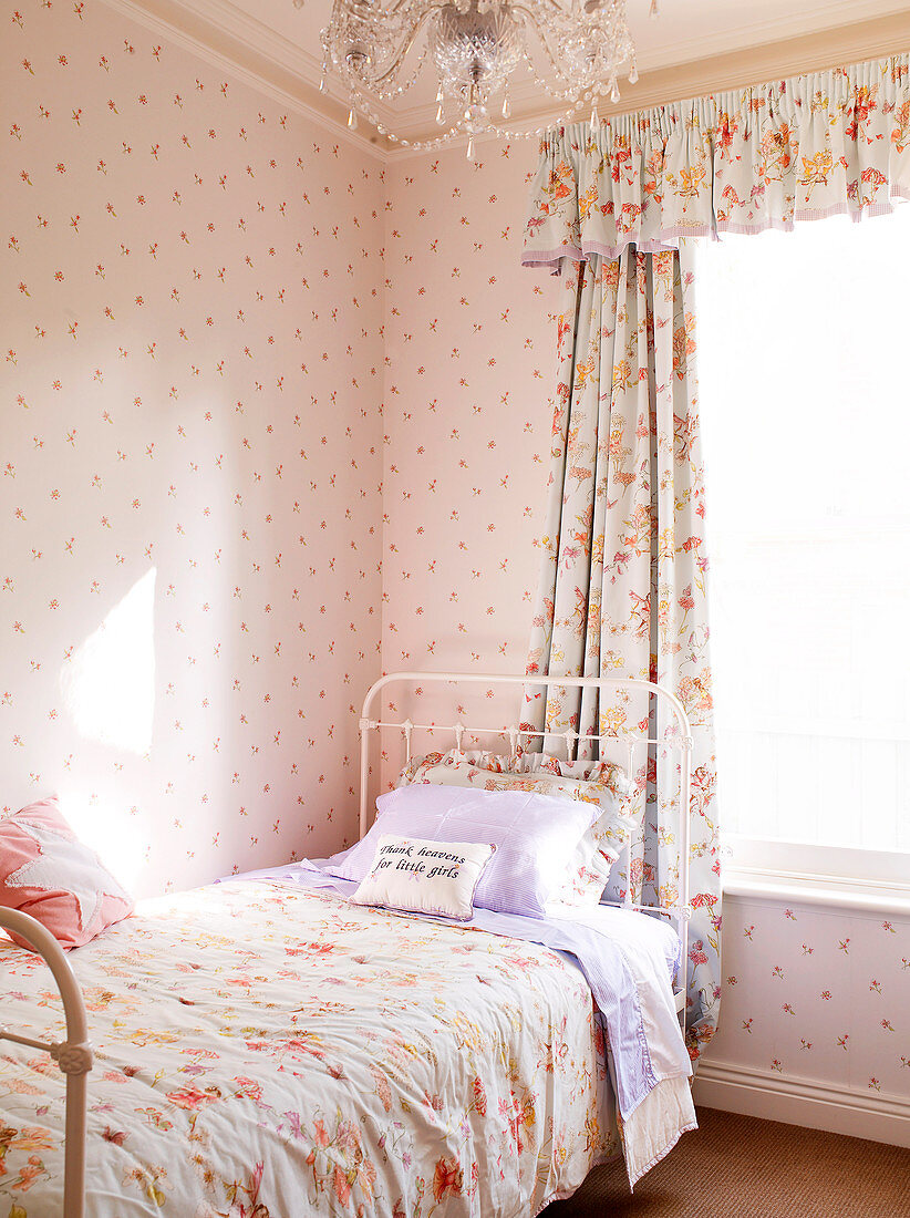 Verträumte Mädchenzimmerecke in zartem Rosa mit Vorhängen und Bettüberwurf im selben Muster