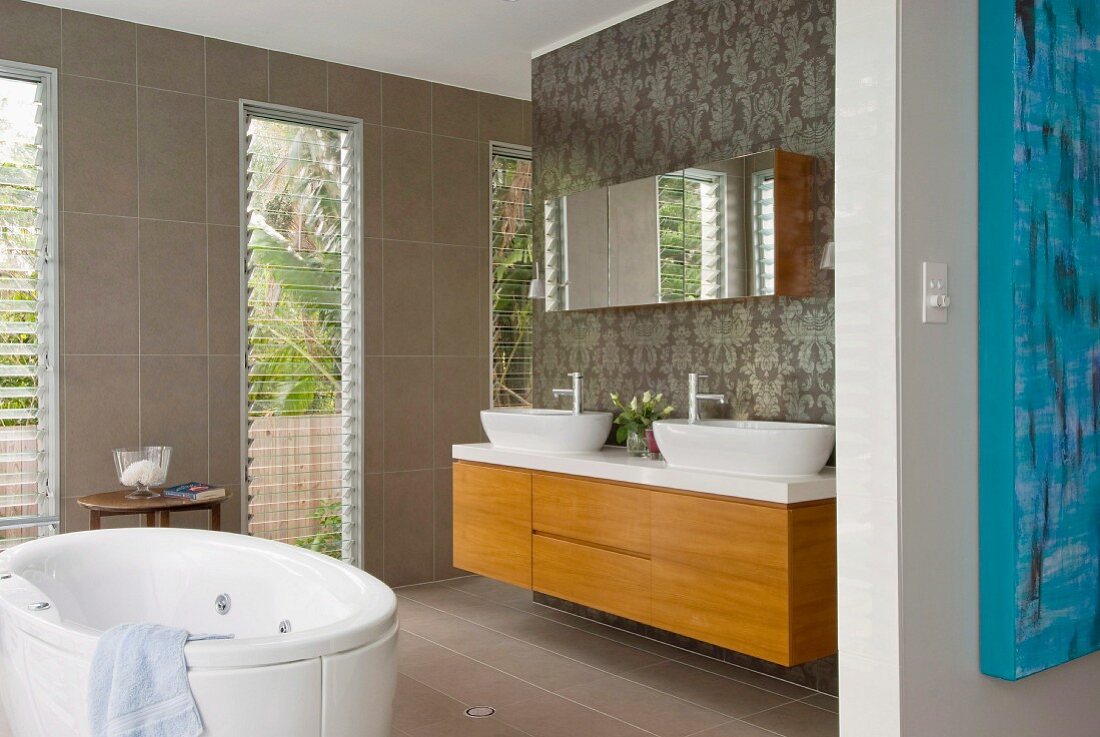 Modernes Bad mit freistehender Badewanne vor raumhohen Fenstern