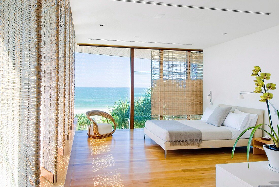 Modernes Schlafzimmer mit Meerblick und drehbarem Sichtschutz aus Rattan