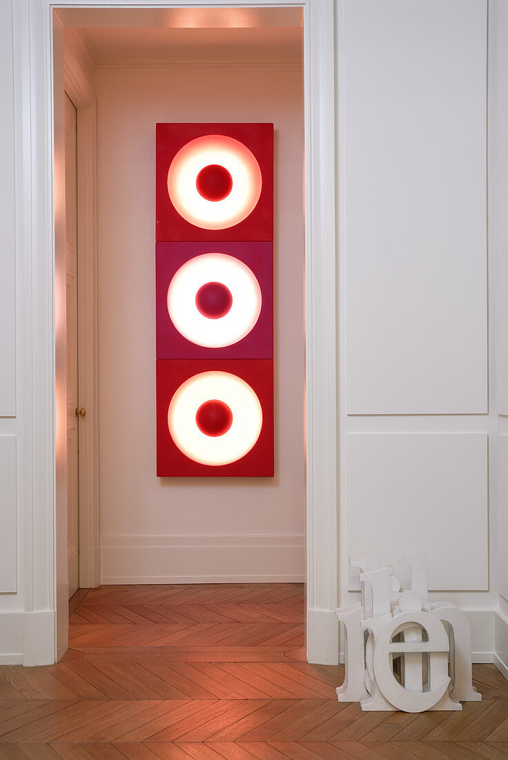 Holzgetäfelter Durchgang zur Diele mit Blick auf rotes Leuchtobjekt im 70er Jahre Stil