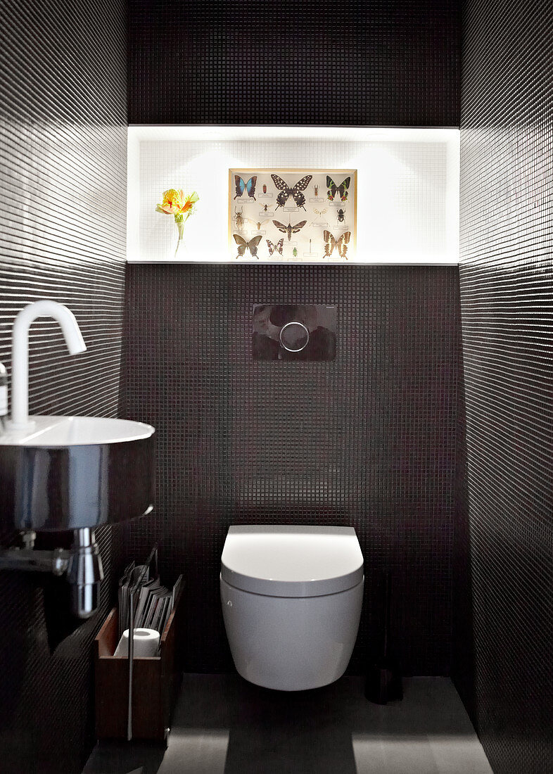Gefliestes Designer Bad mit verchromtem Waschbecken und Bild mit Schmetterlingsmotiven auf Lichtband geklebt