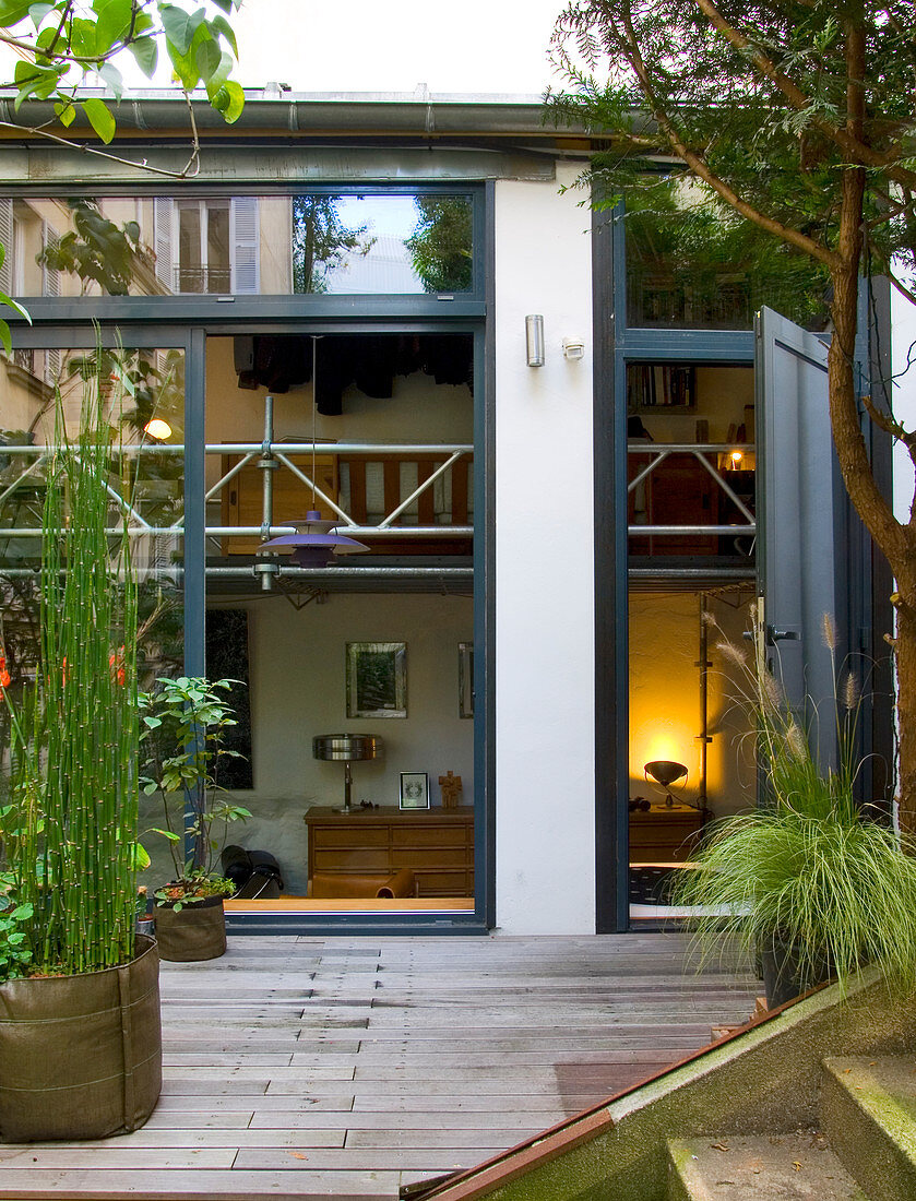 Zweiraum-Maisonette in einem Pariser Hinterhof mit begrünter Holzterrasse - Öffnung der verglasten Fassade bis in Galeriehöhe durch Split-Level-Bauweise